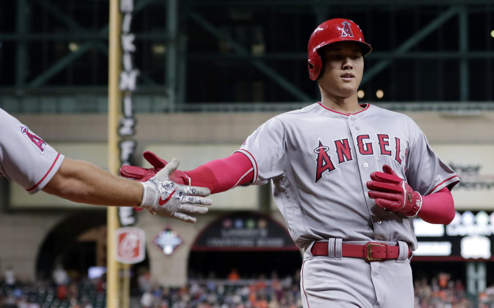 Los Angeles Angels designated hitter Shohei Ohtani (17) is congratulated as he scores the fourth run of the inning on the double by Andrelton Simmons during the sixth inning of a baseball game against the Houston Astros, Thursday, Aug. 30, 2018, in Houston. (AP Photo/Michael Wyke)