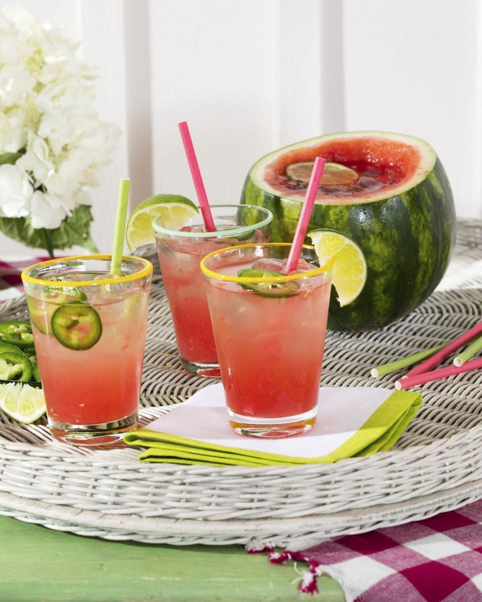 spicy watermelon cocktail served in a hollowed out watermelon on a wicker tray