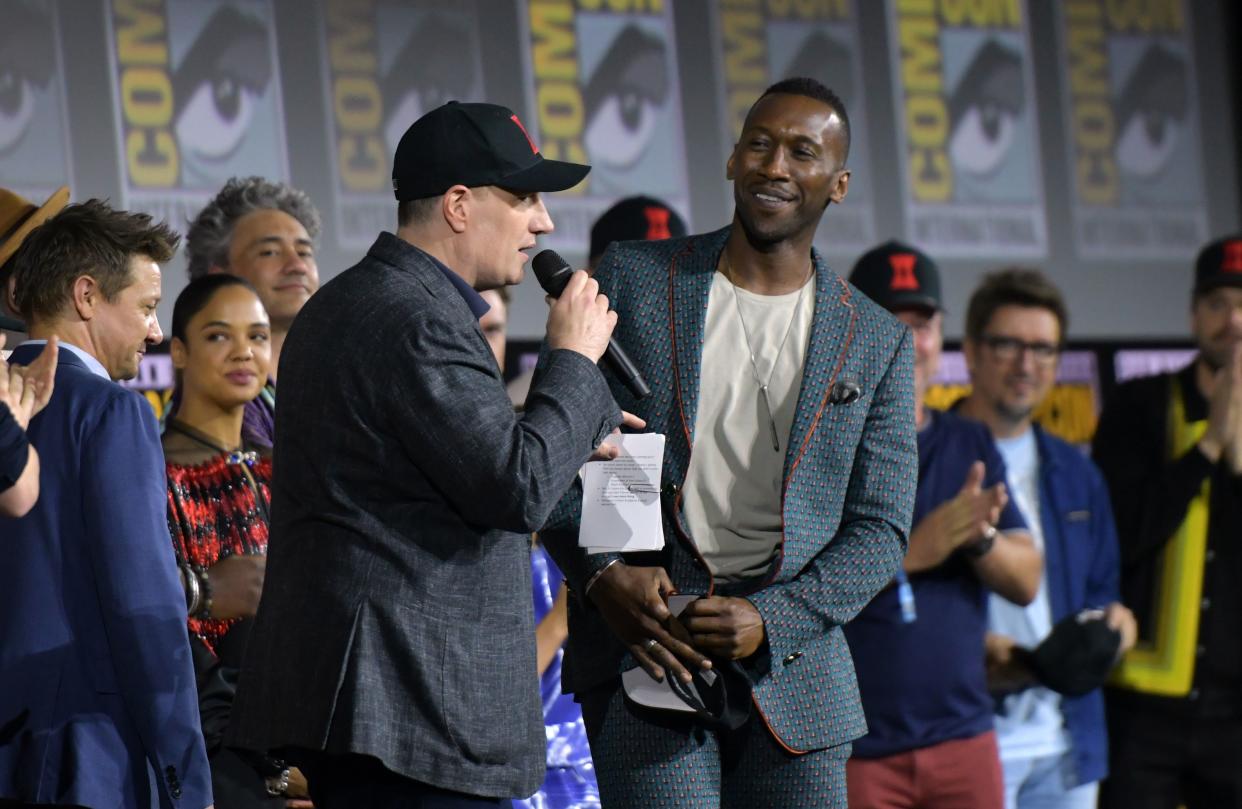 President of Marvel studios Kevin Feige (C) welcomes US actor Mahershala Ali on stage during the Marvel panel in Hall H of the Convention Center during Comic Con in San Diego, California on July 20, 2019. (Photo by Chris Delmas / AFP)        (Photo credit should read CHRIS DELMAS/AFP/Getty Images)