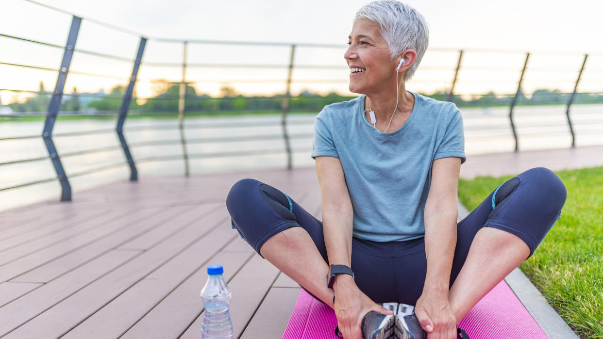  Mature woman stretching after training. 