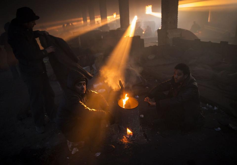 <p>Flüchtlinge wärmen sich in einer verlassenen Lagerhalle im serbischen Belgrad an einem Feuer. (Bild: Srdjan Stevanovic/Getty Images) </p>