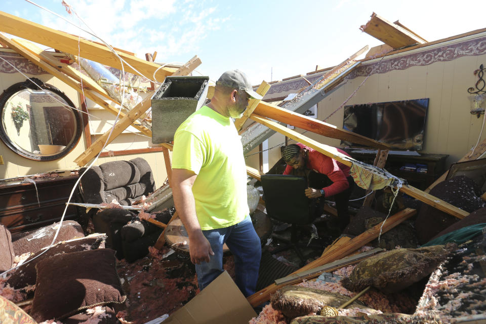 Monte Tynes, left and O'Brian McGee look to see if they can clear a way through of what used to be the living room of McGee's parents, Saturday 25, 2023, in Amory, Miss. Emergency officials in Mississippi say several people have been killed by tornadoes that tore through the state on Friday night, destroying buildings and knocking out power as severe weather produced hail the size of golf balls moved through several southern states. (Thomas Wells/The Northeast Mississippi Daily Journal via AP)