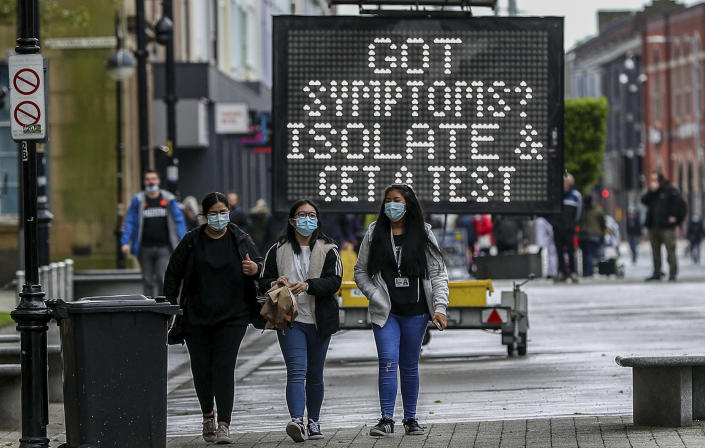 An electronic notice board advises local people to isolate and get tested if they have coronavirus symptoms, in the town centre of Bolton, England, Tuesday May 25, 2021. The British government on Tuesday is facing accusations of introducing local lockdowns by stealth after it published new guidelines for eight areas in England, including Bolton, that it says are hotspots for the coronavirus variant first identified in India.(Peter Byrne/PA via AP)