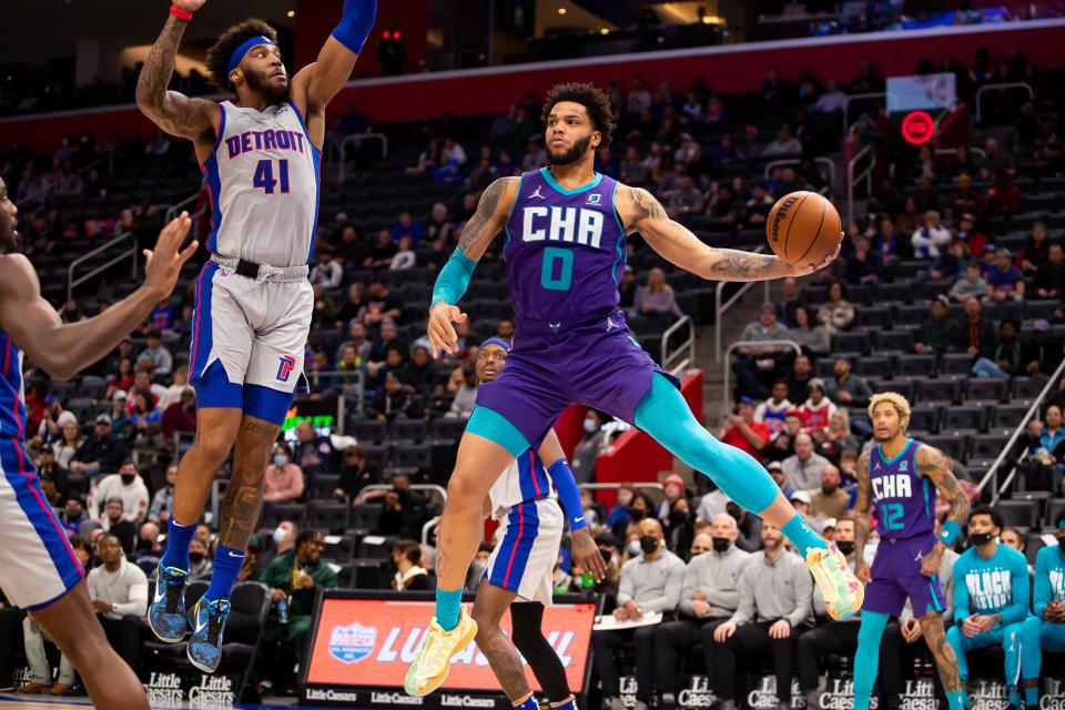 Charlotte Hornets forward Miles Bridges looks to pass as he is defended by Detroit Pistons forward Saddiq Bey at Little Caesars Arena, Feb. 11, 2022.