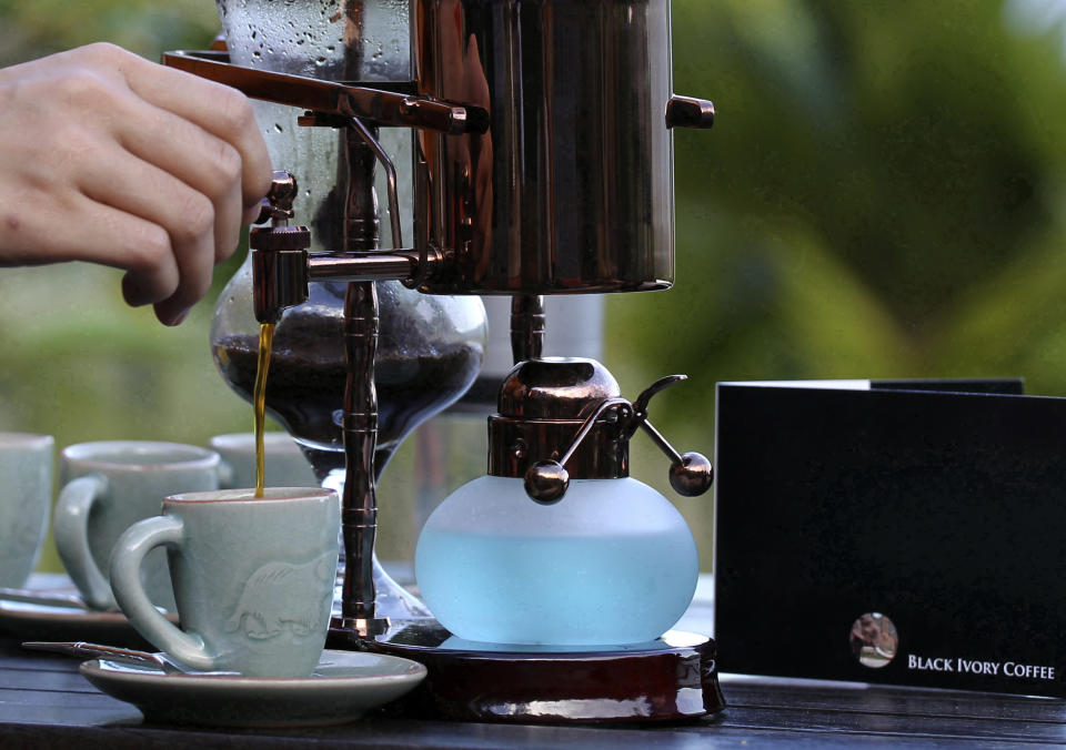 In this photo taken Dec. 3, 2012, a waitress pours the $1,100 per kilogram ($500 per pound) Black Ivory coffee into a cup at a hotel restaurant in Chiang Rai province, northern Thailand. A Canadian entrepreneur with a background in civet coffee has teamed up with a herd of 20 elephants, gourmet roasters and one of the country's top hotels to produce the Black Ivory, a new blend from the hills of northern Thailand and the excrement of elephants which ranks among the world's most expensive cups of coffee. (AP Photo/Apichart Weerawong)