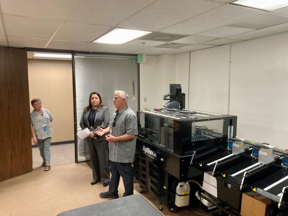 From left: Pueblo County Chief Deputy Clerk Karen Long, Clerk Candace Rivera and Election Director Dan Lepik stand in front of the Agilis ballot sorting machine at the new office of the Pueblo County elections department in the Wells Fargo Building on July 18, 2023. At the department's previous office, this machine was previously on another floor as most of the rest of the election equipment. Having this machine on the same floor as everything else will help optimize the process and improve the flow of accurate ballot counting, officials said.