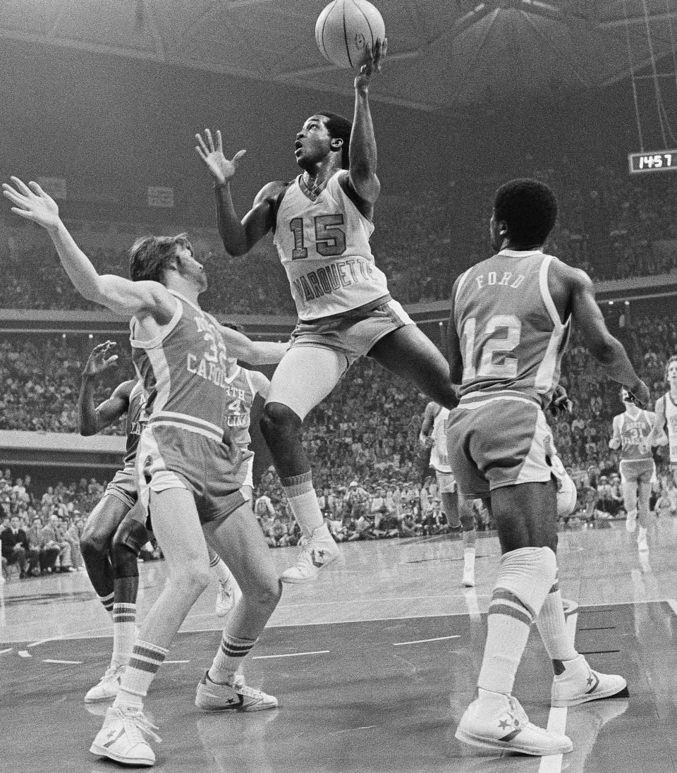 FILE - Butch Lee (15) of Marquette goes high to score against North Carolina during first period in the NCAA college basketball championship, March 28, 1977 in Atlanta, Ga. North Carolina's Tom Zaliagiris (32), left, attempts to stop Lee. (AP Photo/File)