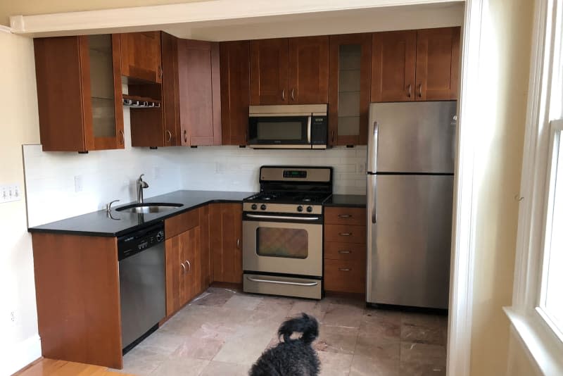 Before kitchen, dark wood cabinets, black countertops