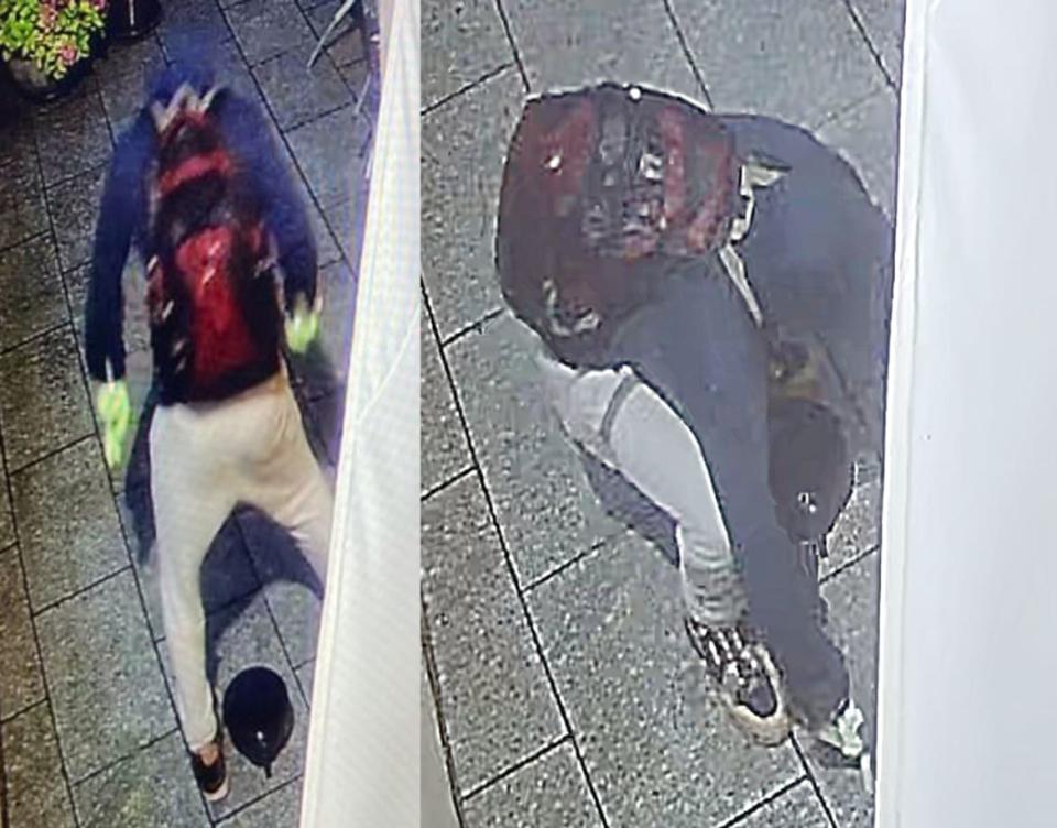 An image released by police shows the suspect at the scene of the crime, wearing gloves and a red backpack.