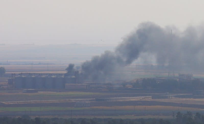 Smoke rises from a building near the Syrian town of Ras al-Ain as seen from the Turkish border town of Ceylanpinar