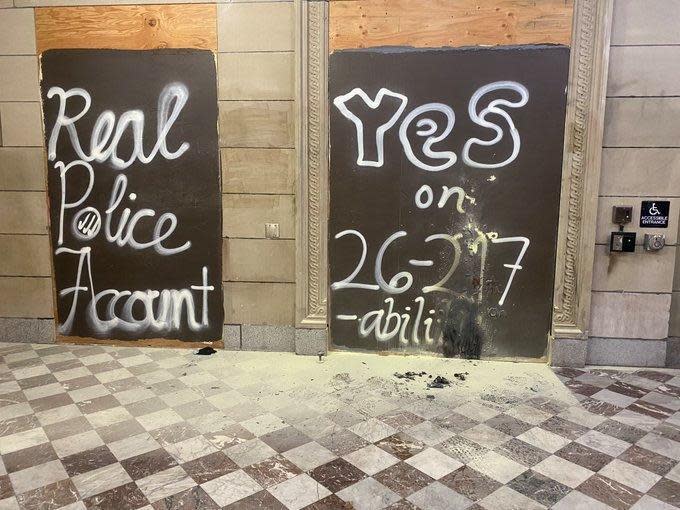 A photo from CBS News Portland affiliate KOIN shows damage at a boarded up entrance of Portland City Hall after investigators say someone set or threw a burning object near the door. / Credit: Jennifer Dowling/KOIN