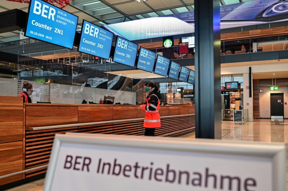 Eine Frau mit Maske steht im Terminal 1 vom Hauptstadtflughafen BER vor einem Schalter.<span class="copyright">Patrick Pleul / dpa</span>