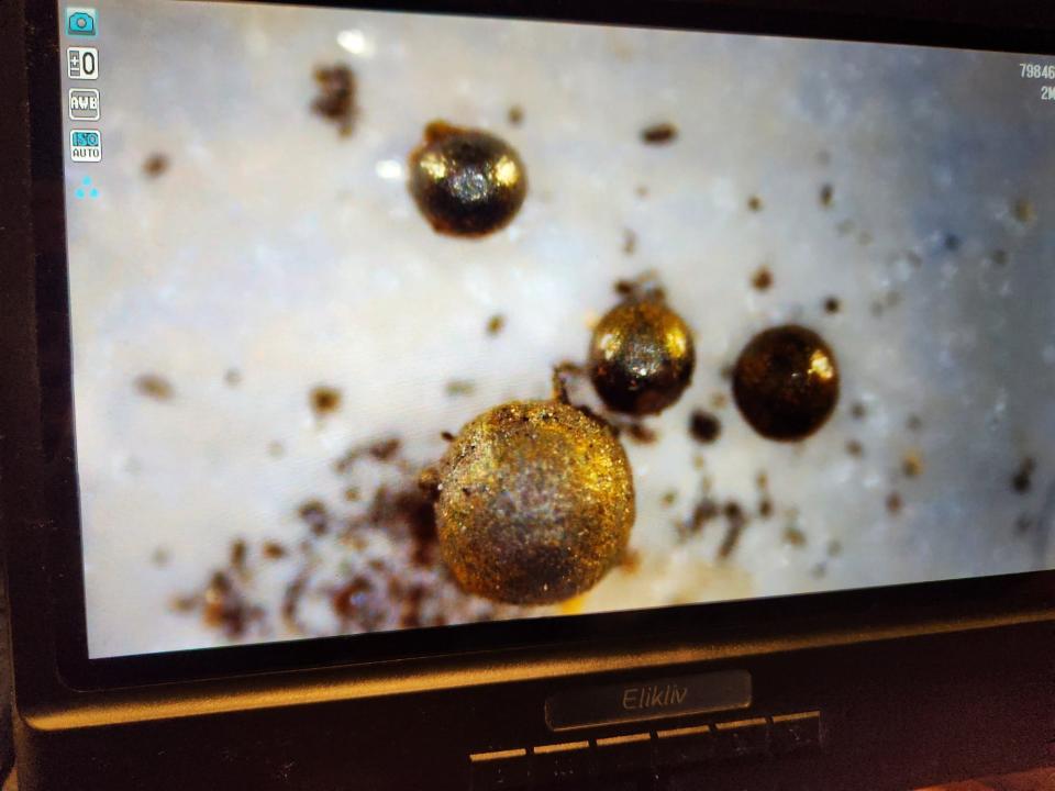 a picture shows small spheres which seems to be made of metal, shown on a close up of a screen.