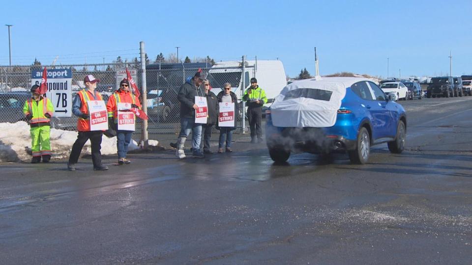 A replacement worker at Autoport in Eastern Passage, N.S. drives a vehicle past Unifor members on strike Tuesday. 