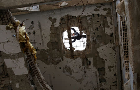 Ahmed al-Kadiri, 18, demonstrates his Parkour skills on a damaged building in the rebel-held city of Inkhil, west of Deraa, Syria, February 4, 2017. Injuries are frequent among the group; Ahmed once twisted his neck. REUTERS/Alaa Al-Faqir