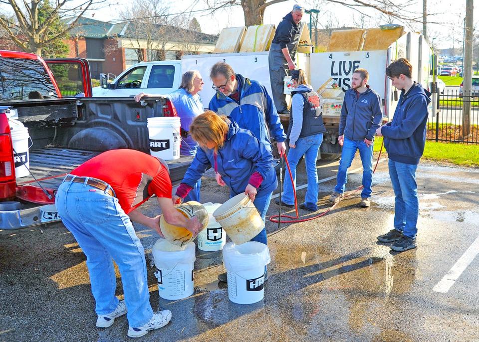 Wayne County Soil and Water Conservation District employees help pond owners prepare their fish purchases for transport.