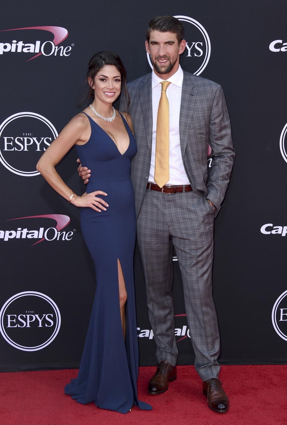 Nicole Johnson wearing a navy blue gown with husband and Olympic swimmer Michael Phelps