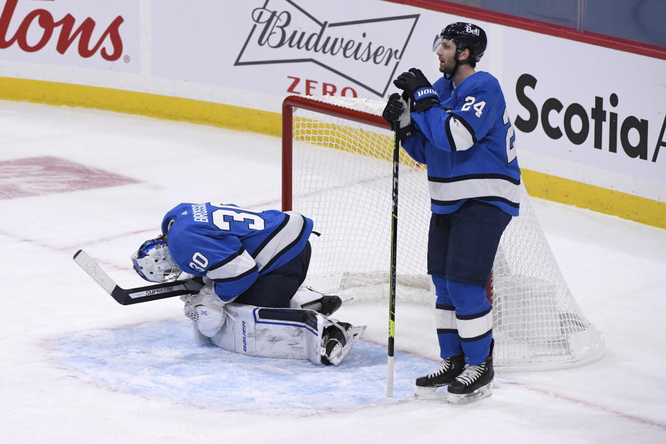 Winnipeg Jets goaltender Laurent Brossoit (30) and Derek Forbort (24) react after the Edmonton Oilers scored the game-winning goal with less than a second left in an NHL hockey game, Sunday, Jan. 24, 2021, in Winnipeg, Manitoba. (Fred Greenslade/The Canadian Press via AP)