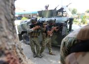 Afghan security forces keep watch near the site of an attack on a jail compound in Jalalabad