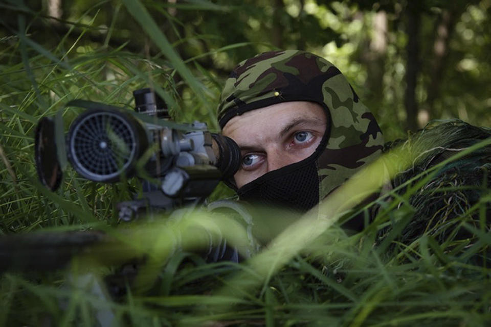 In this photo released by the Russian Defense Ministry Press Service on Thursday, Aug. 10, 2023, a Russian sniper looks from his position toward Ukrainian positions at the Zapad (West) group of Russian troops at an undisclosed location of Ukraine. (Russian Defense Ministry Press Service via AP)