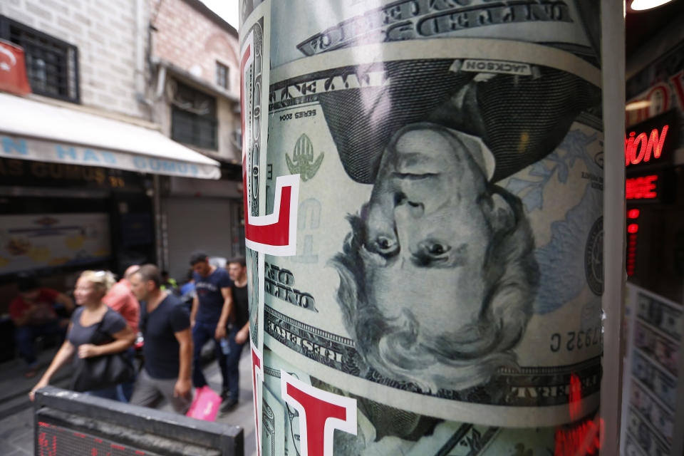 People walk past a currency exchange shop in Istanbul, Friday, Aug. 17, 2018. Turkey's lira currency fell once again, as Turkey and the United States exchanged new threats of sanctions Friday, keeping alive a diplomatic and financial crisis. (AP Photo/Lefteris Pitarakis)