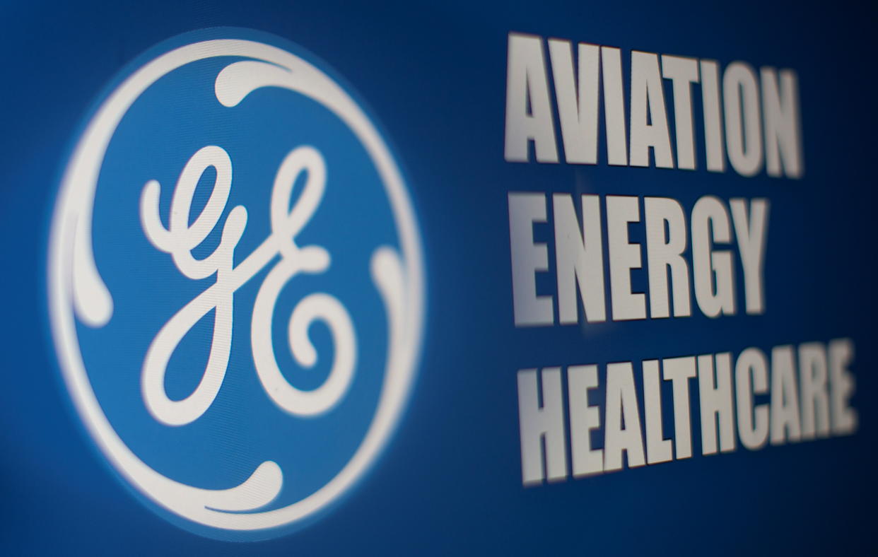 General Electric logo is seen through magnifier in front of displayed Aviation, Energy, Healthcare words in this illustration taken, November 9, 2021. REUTERS/Dado Ruvic/Illustration
