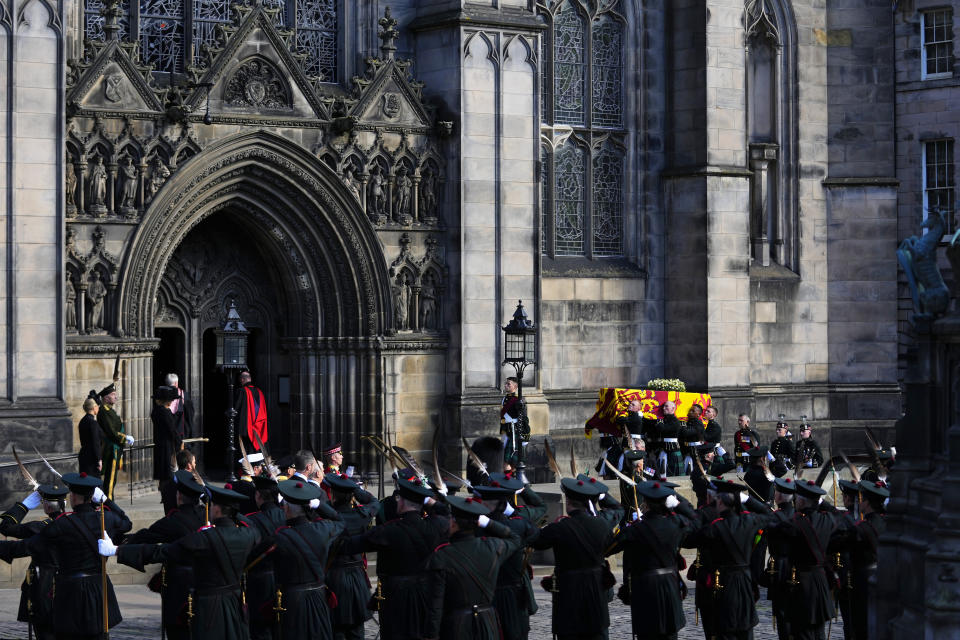 Royal Company of Archers soldiers salute as Queen Elizabeth's coffin arrives to St Giles Cathedral on the Royal Mile in Edinburgh, Scotland, Monday, Sept. 12, 2022. At the Cathedral there will be a Service to celebrate the life of The Queen and her connection to Scotland. (AP Photo/Petr David Josek)
