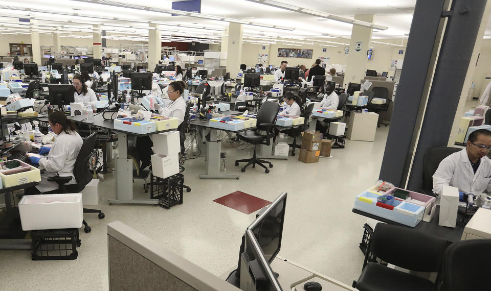 In this March 10, 2020, photo, lab workers log in specimen samples at the Mayo Clinic Superior Drive facility in Rochester, Minn. Vice President Mike Pence has an appointment Tuesday at Minnesota’s Mayo Clinic to learn about a new coronavirus testing “moonshot” that has the famed clinic partnering with the state and its flagship university to quickly boost the state's capacity to 20,000 tests a day. (David Joles/Star Tribune via AP)