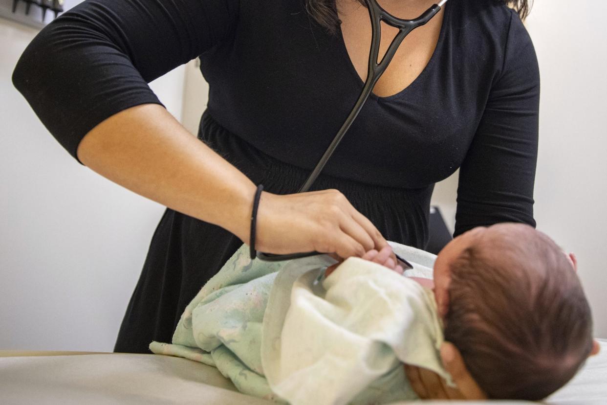 A pediatrician examines a newborn. Choosing a primary care doctor for your children can be overwhelming, but manageable if you follow a few simple steps.