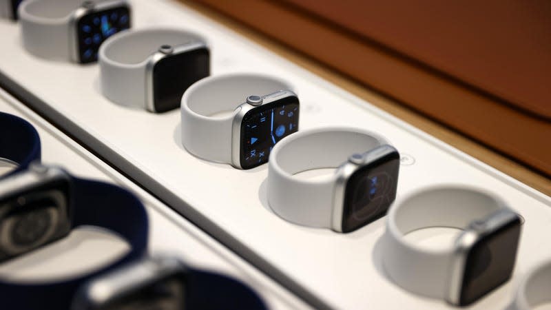 A line of Apple Watches on display, some showing the front and some showing backs.