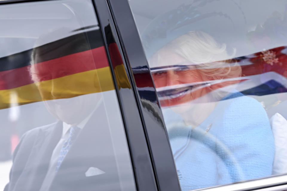 Britain's King Charles III, left, and Camilla, the Queen Consort, right, drive in a car after they arrived at the airport in Berlin, Wednesday, March 29, 2023. King Charles III arrives Wednesday for a three-day official visit to Germany. (Britta Pedersen/dpa via AP)