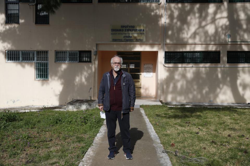 Prison school director Petros Damianos poses outside the building of Avlona's prison school, north of Athens, Wednesday, Feb. 10, 2021. With Greece's schools shut due to the pandemic, all lessons have gone online. But the online world isn't within reach of everyone _ and particularly not within reach of the students of Avlona Special Youth Detention Center, where internet devices are banned by law from the cells. (AP Photo/Thanassis Stavrakis)