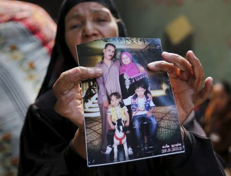 Fathia Hashem, mother of Amr Abushanab, who died in police custody, shows a picture of her son and his family during an interview with Reuters at their house in Tahanoub village, Egypt, November 30, 2015. REUTERS/Amr Abdallah Dalsh