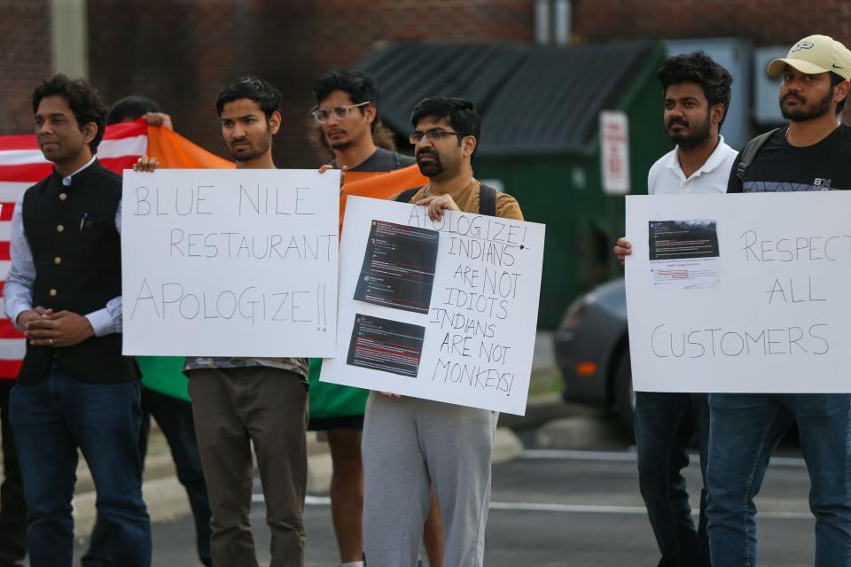 Purdue University students hold signs and protest against the owner of the Blue Nile Restaurant over alleged racist comments he made about Indians, on May 5, 2023, in West Lafayette, Ind.