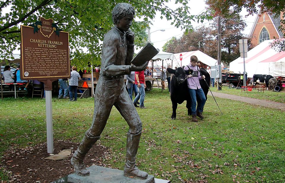 David Carroll walks his steer near the Charles Kettering statue in Central Park waiting to show during the Loudonville Livestock Club market steer show at the Loudonville Street Fair on Thursday, Oct. 7, 2021. TOM E. PUSKAR/TIMES-GAZETTE.COM