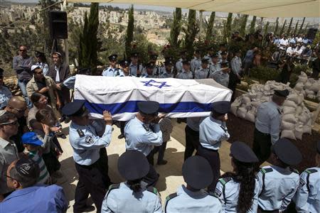 Israeli policemen carry their comrade Baruch Mizrahi's flag-draped coffin during his funeral at the Mount Herzl military cemetery in Jerusalem April 16, 2014. REUTERS/Baz Ratner