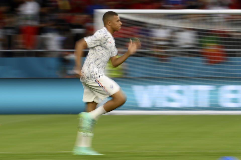 France's Kylian Mbappe runs during warmup before the Euro 2020 soccer championship group F match between Portugal and France at the Puskas Arena in Budapest, Wednesday, June 23, 2021. (Franck Fife, Pool photo via AP)