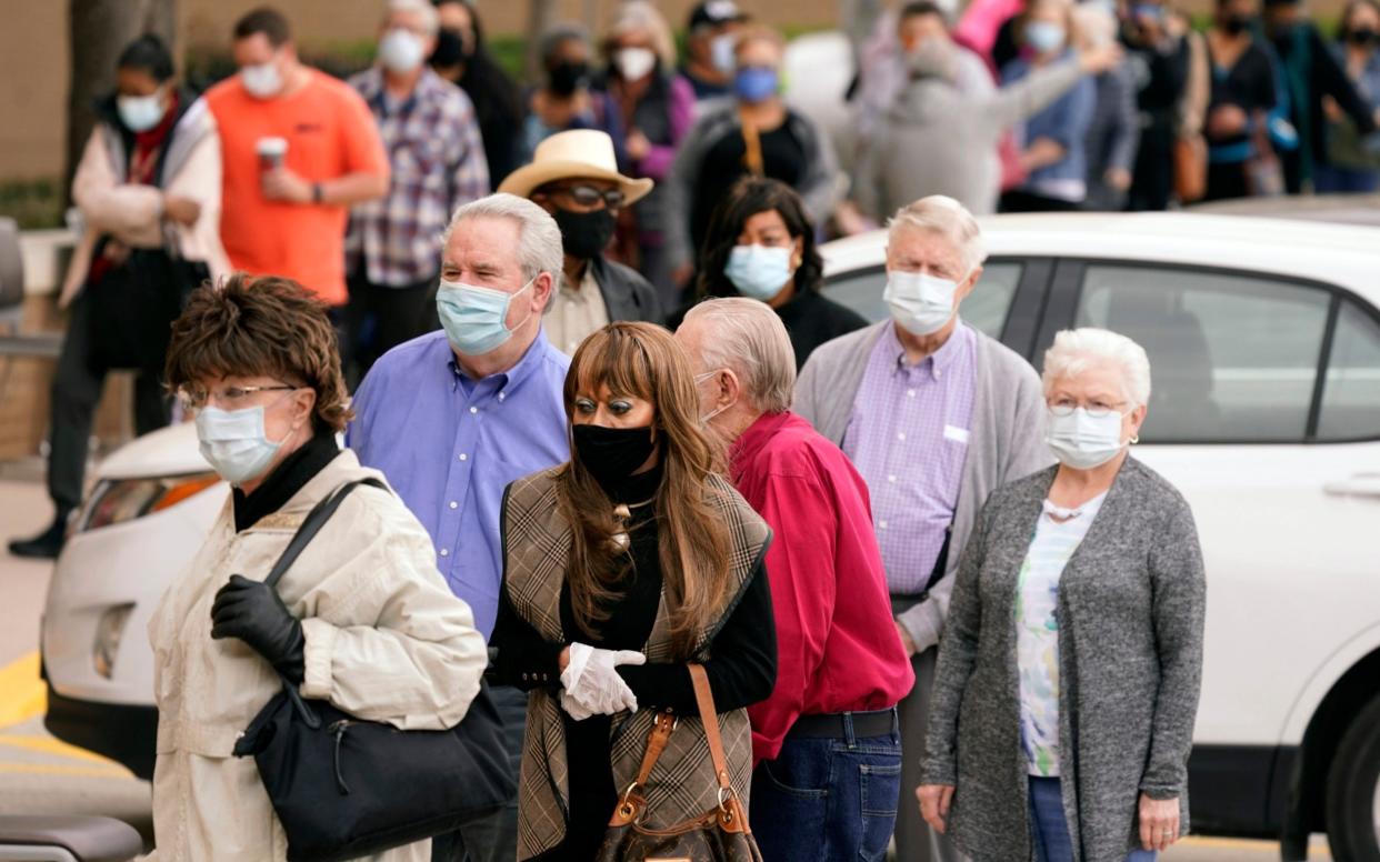 People wait in line to receive a COVID-19 vaccination at Methodist Hospital in the Oak Cliff section of Dallas. Texas - AP