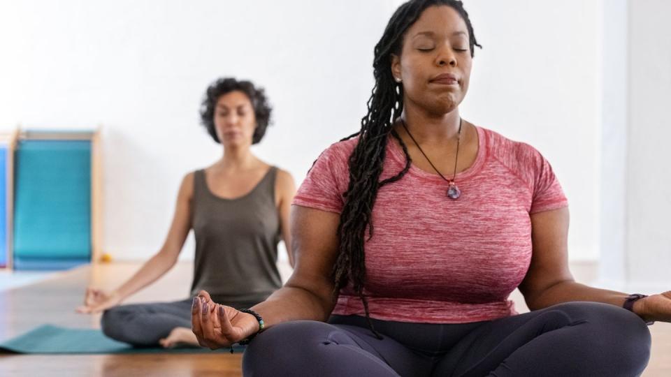 healthy african woman meditating in yoga class