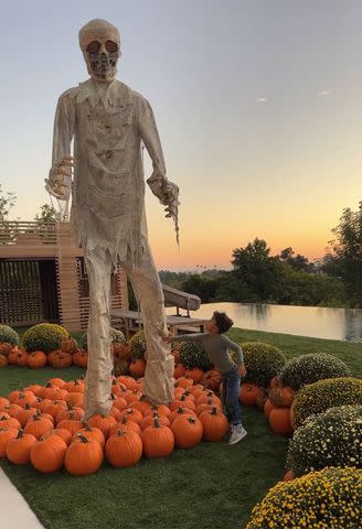 <p>Chrissy Teigen/Instagram</p> Chrissy Teigen and John Legend's son Miles stands next to the giant zombie skeleton in their backyard.