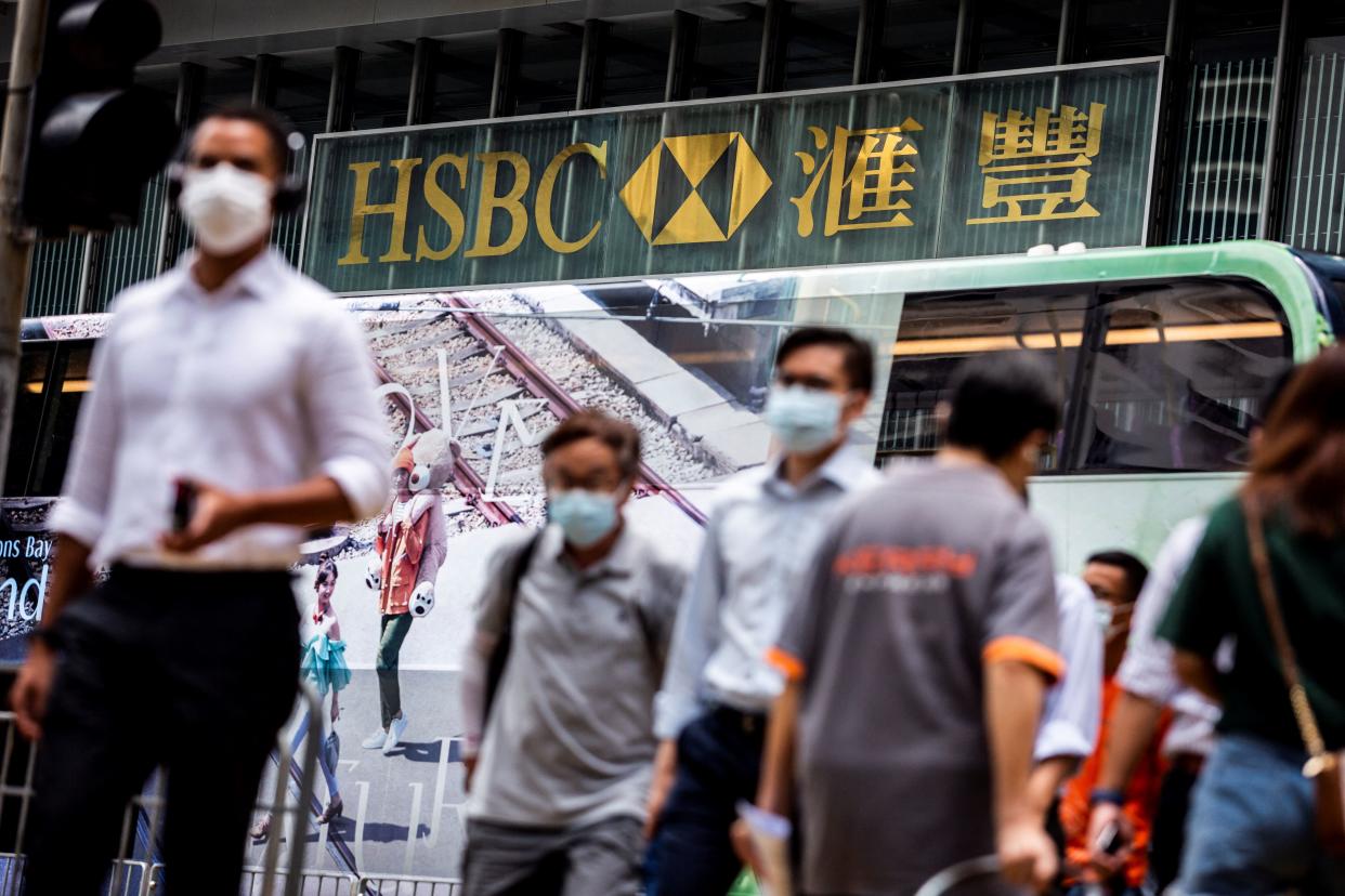 Pedestrians cross the road outside HSBC Main Building in Hong Kong on August 2, 2021. (Photo by ISAAC LAWRENCE / AFP) (Photo by ISAAC LAWRENCE/AFP via Getty Images)