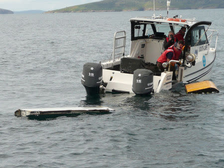 A Boeing 777 flaperon (L) cut down to match the one from flight MH370 found on Reunion island off the coast of Africa in 2015, floats after being lowered into water to discover its drift characteristics by Commonwealth Scientific and Industrial Research Organisation researchers in Tasmania, Australia, in this handout image taken March 23, 2017. CSIRO/Handout via REUTERS