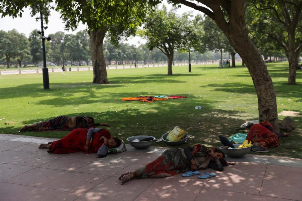 Women labourers rest in the shade of a tree near India Gate, in New Delhi, on May 15 (Reuters)