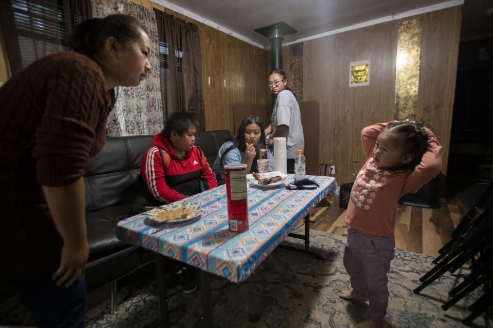 A woman with her children gathered around a table