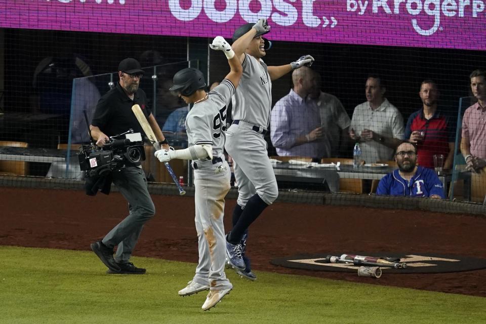 New York Yankees' Oswaldo Cabrera (95) and Giancarlo Stanton, right, celebrate Stanton's solo home run in the fifth inning of the second baseball game of a doubleheader against the Texas Rangers in Arlington, Texas, Tuesday, Oct. 4, 2022. (AP Photo/Tony Gutierrez)