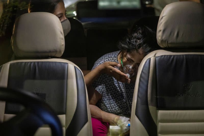 A person with a breathing problem receives oxygen support for free inside her car at a Gurudwara, in Ghaziabad