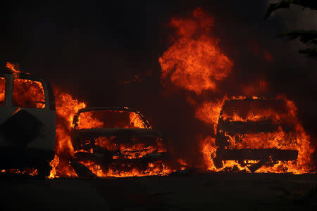 Cars burn along with a home during the Lilac Fire, a fast moving wild fire in Bonsall, California, U.S., December 7, 2017. REUTERS/Mike Blake