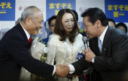 Japan's former health minister Yoichi Masuzoe (L) shakes hands with his supporter at his office, following local media reports that he is certain to be elected as the new Tokyo Governor, in Tokyo February 9, 2014. REUTERS/Yuya Shino