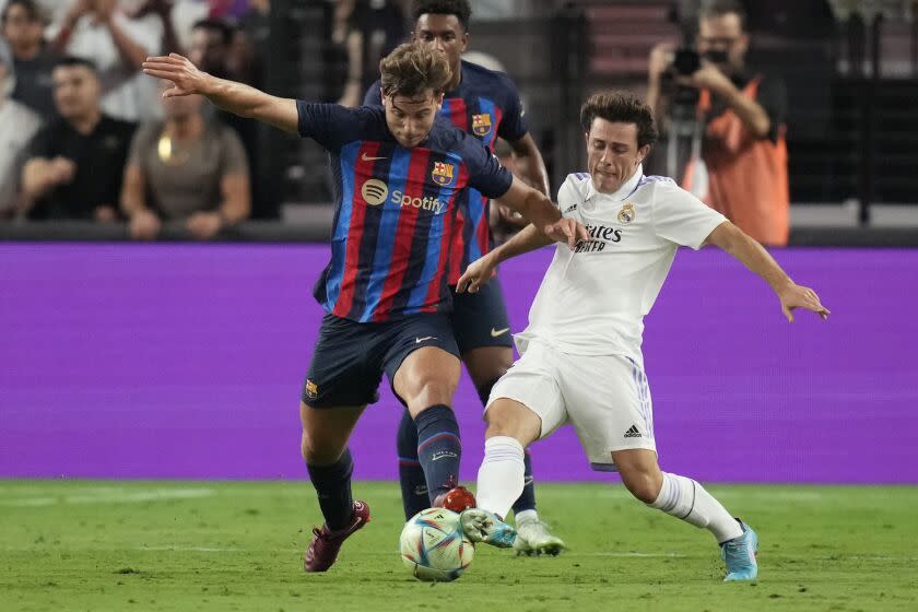 Barcelona's Nico Gonzalez, left, and Real Madrid's Alvaro Odriozola battle for the ball during the second half of a friendly soccer match Saturday, July 23, 2022, in Las Vegas. (AP Photo/John Locher)