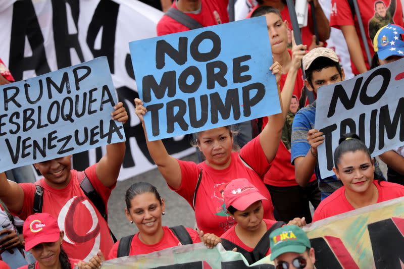 FILE PHOTO: Supporters of Venezuela's President Nicolas Maduro hold anti-trump banners during a rally against the U.S. sanctions on Venezuela, in Caracas